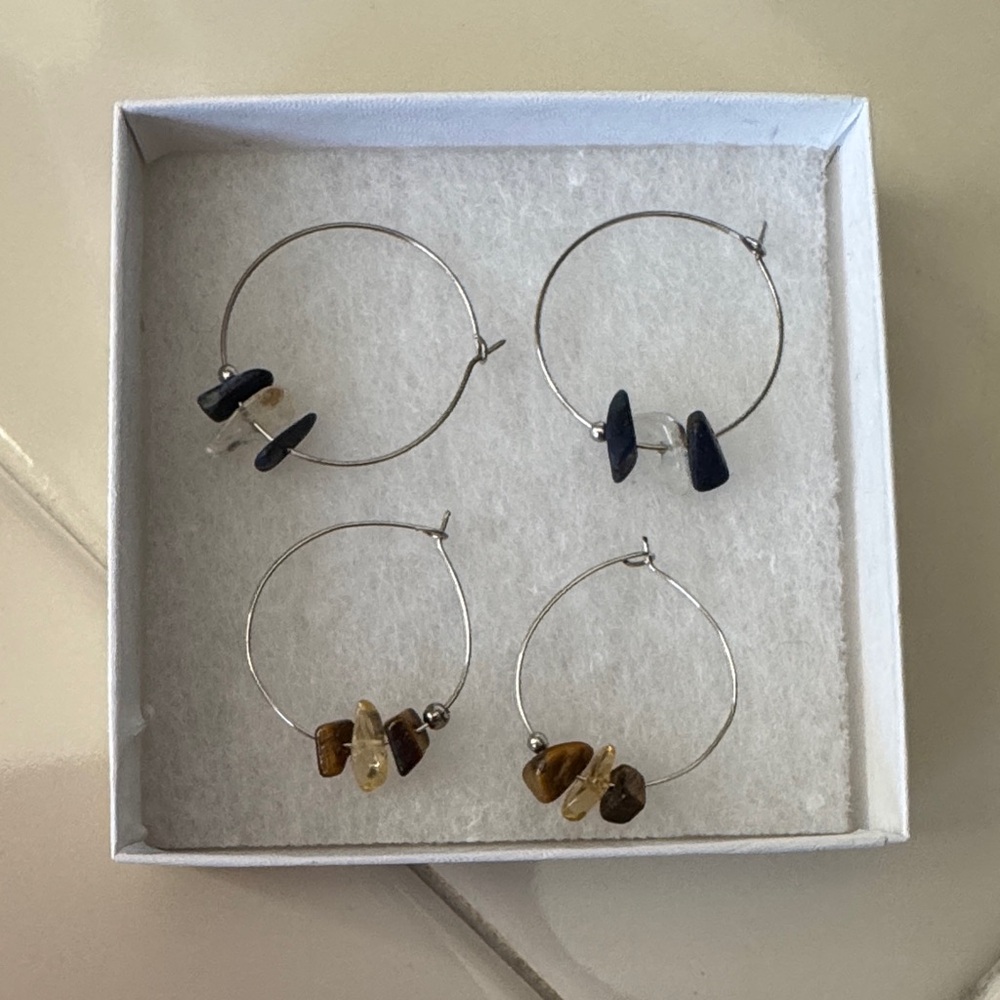 Two pairs of simple hoop earrings with small stones.